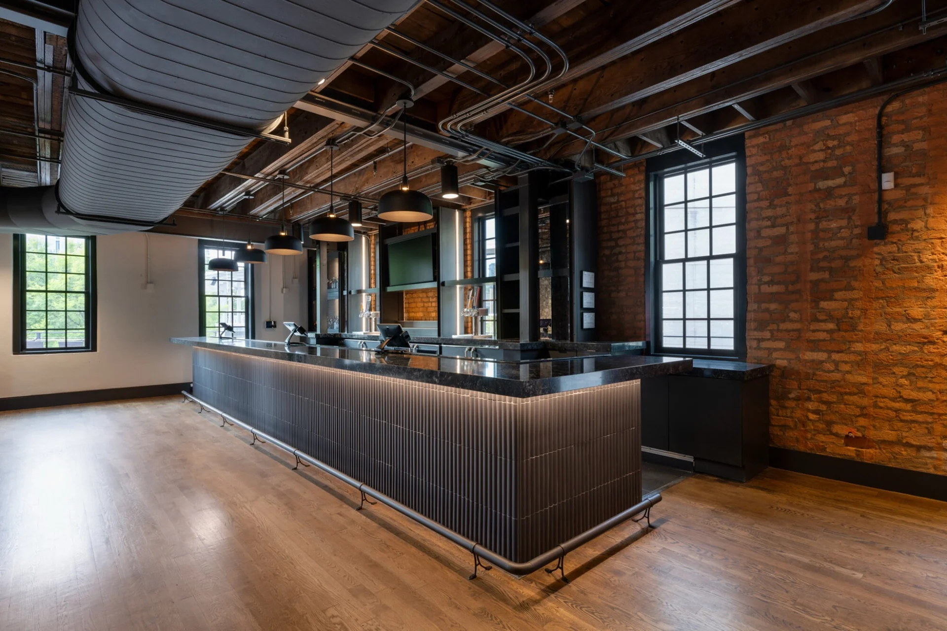 Custom bar millwork inside an exposed-brick hospitality interior
