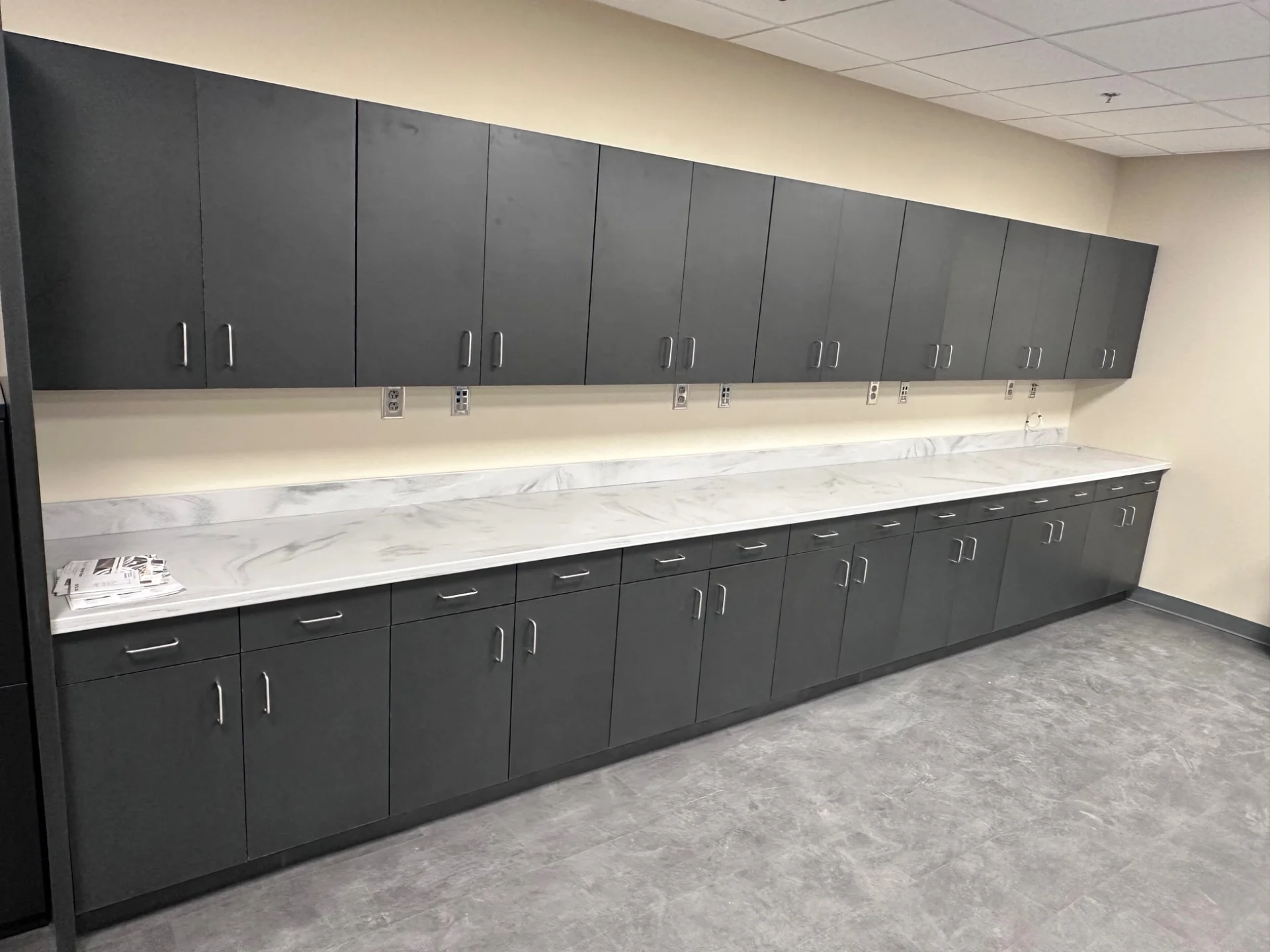 Long run of dark upper and base cabinets with light countertop