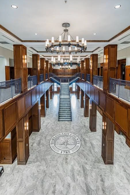 Two-story wood-paneled public interior with architectural columns